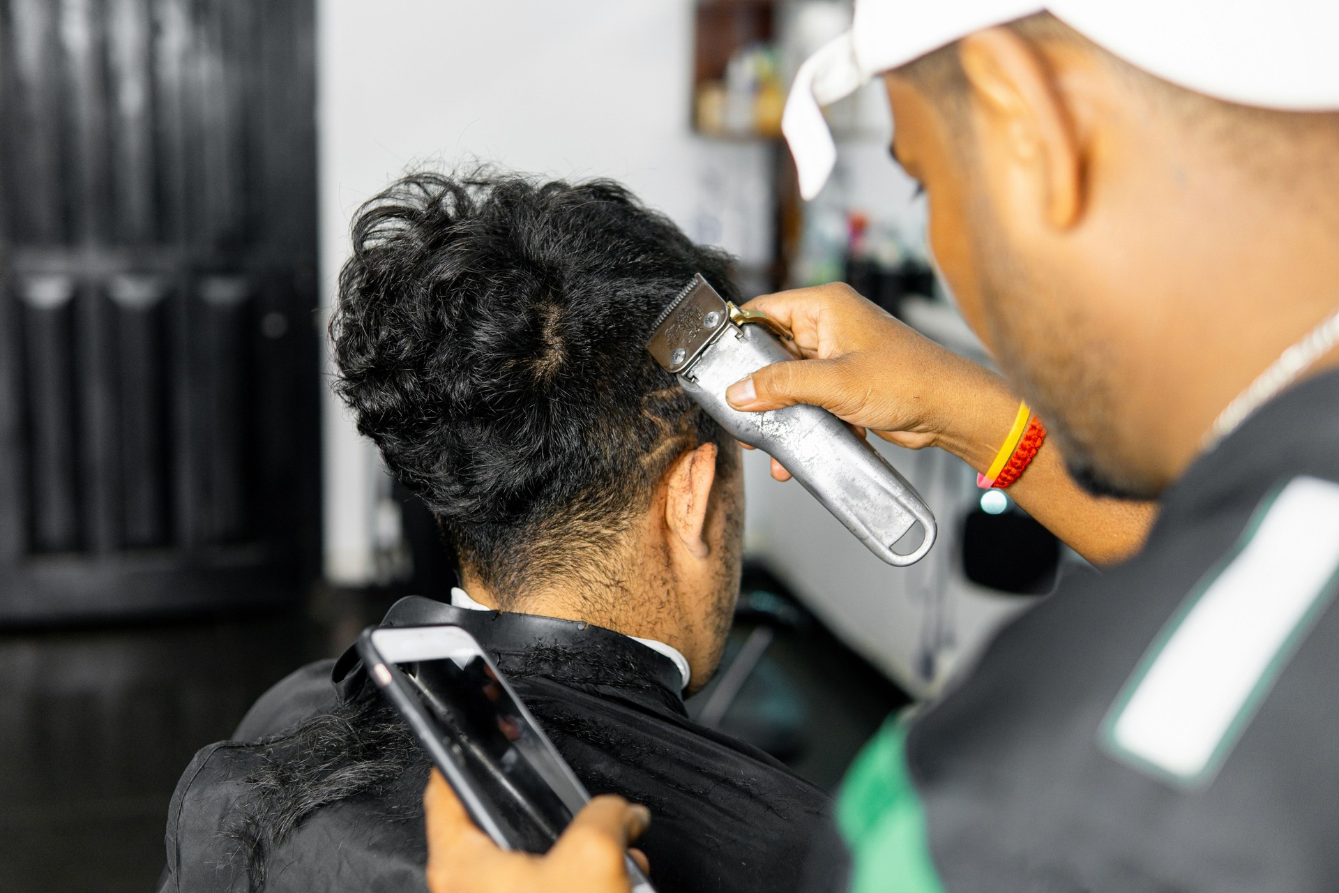 Professional Barber Giving a Man a Haircut in Salon